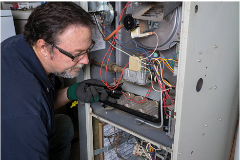 Technician inspecting a residential gas furnace.